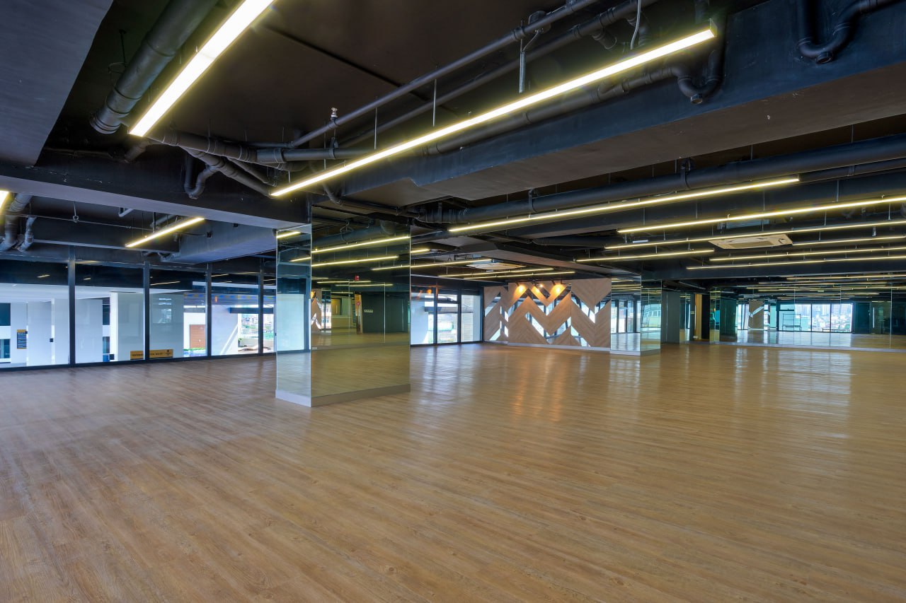 a condo amenity large dance studio with a wood floor surrounding it with glasses