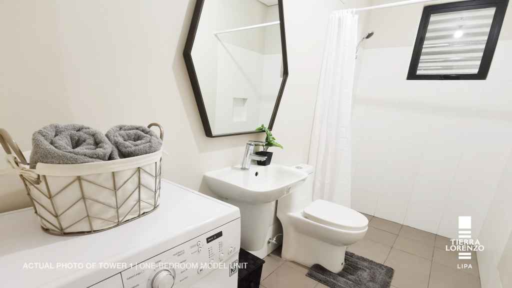 a bathroom with a mirror and a sink in the 1 BR Adria Tower at Tierra Lorenzo Lipa